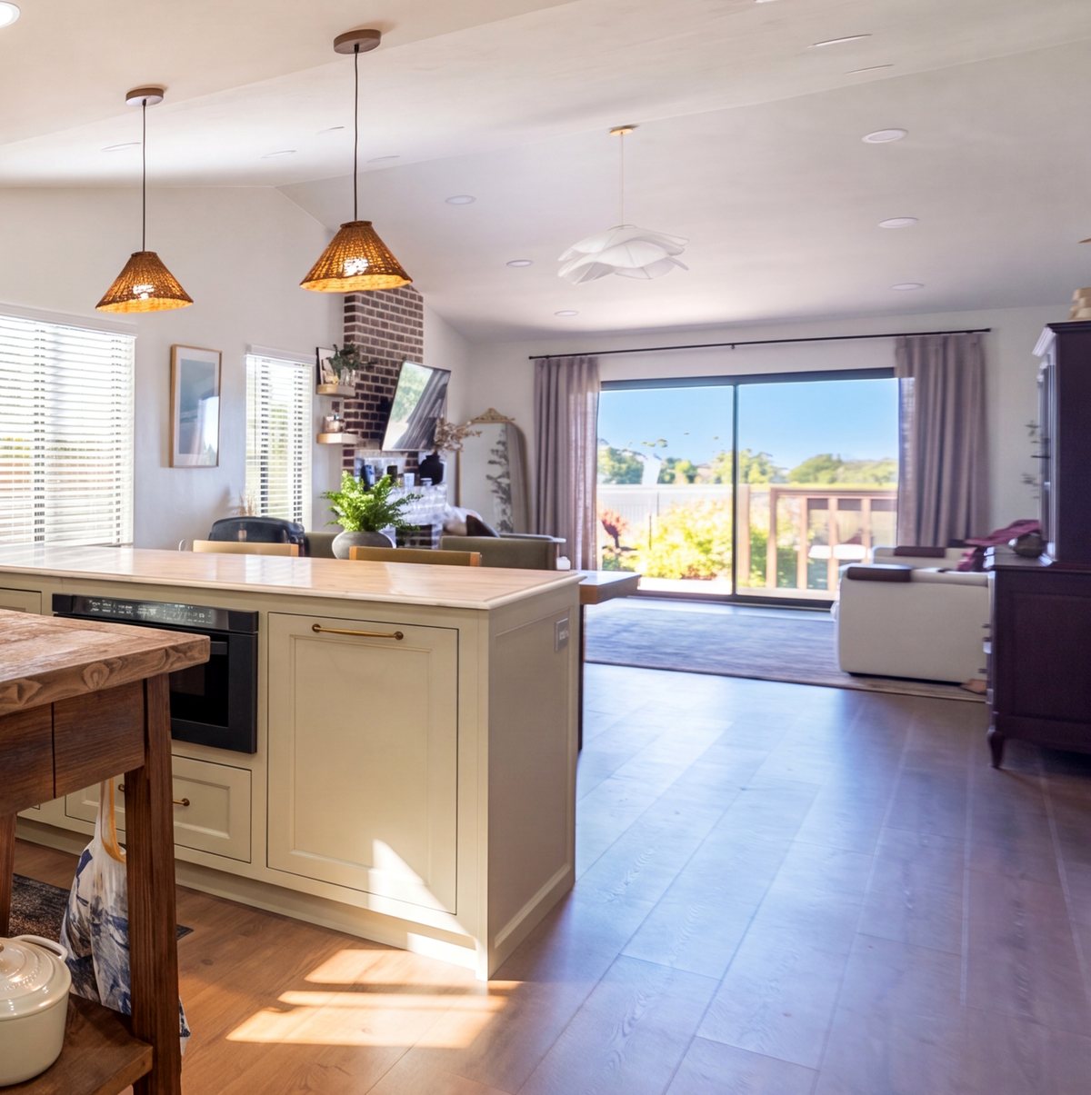 Open plan living room and kitchen with copper pendants and sliding doors to the garden